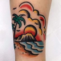 a colorful tattoo on the leg of a person with an island and palm trees in the background