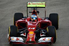 a man driving a red race car on top of a track