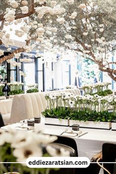 an indoor dining area with tables, chairs and flowers in the center is surrounded by greenery