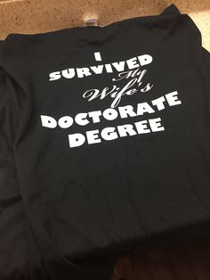 a black t - shirt that says i survived my doctorate degree