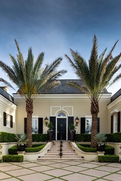 a house with palm trees in front of it and steps leading up to the door