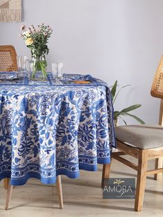 a blue and white table cloth on a wooden chair next to a vase with flowers