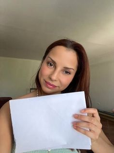 a woman holding up a piece of white paper