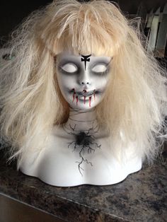 a creepy doll with blonde hair and makeup