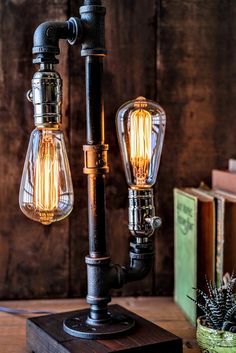 two light bulbs are attached to an old fashioned lamp on top of a wooden table