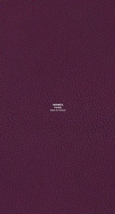 a purple leather textured surface with white stitching on the top and bottom corner