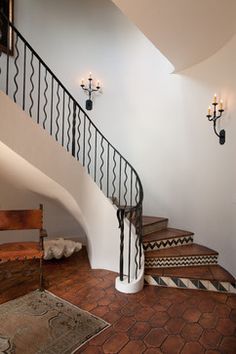 a staircase with wrought iron handrails leading up to the second floor