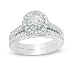 a white gold ring set with diamonds on the band and an oval shaped diamond in the center