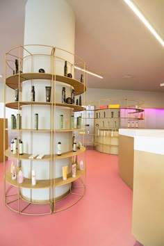 a room filled with lots of bottles and shelves next to a pink floored wall