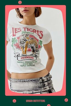 Graphic baby tee with a Les Tigres graphic printed at the front. Fitted tee cropped above the waist with a crew neckline and cap sleeves. Find it exclusively at Urban Outfitters. Features Les Tigres graphic baby tee Fitted tee with a Les Tigres graphic at the front Retro style tiger graphic in a faded finish Cropped silhouette Crew neckline Short sleeves UO exclusive Content + Care 100% Cotton Machine wash Imported Size + Fit Model in White is 5’10" and wearing size Small Measurements taken from Trendy Streetwear Tops From Urban Outfitters, Trendy Urban Outfitters Streetwear Tops, Graphic Crop Top T-shirt With Text Print, Summer Cropped T-shirt With Screen Print Fitted Style, Summer Fitted Cropped T-shirt With Screen Print, Urban Outfitters Letter Print Tops For Spring, Fitted Cropped T-shirt With Screen Print For Summer, Cropped Graphic Tee With Logo Print, Summer Fitted Cropped T-shirt With Slogan