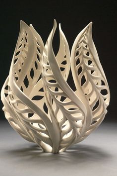 an intricate white vase sitting on top of a table