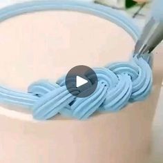 a close up of a cake with blue icing and a crochet hook