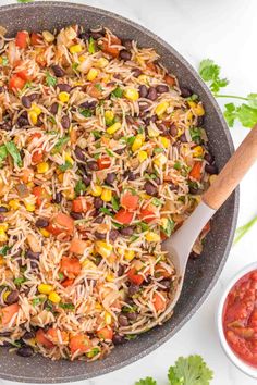 mexican rice salad in a skillet with wooden spoon