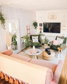 a living room with couches, chairs and a flat screen tv on the wall