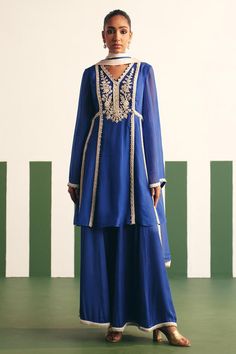 Cobalt blue peplum anarkali with floral embroidered yoke and sequins, nalki, cutdana work. Paired with a sharara and dual tone dupatta.
Components: 3
Pattern: Embroidery
Type Of Work: Sequins, Nalki, Cutdana, Floral
Neckline: V Neck
Sleeve Type: Bell Sleeves
Fabric: Anarkali: Organza, Sharara: Cotton Satin
Color: Blue
Other Details: 
Embroidered hem sharara
Occasion: Sangeet - Aza Fashions Traditional Blue Embroidered Sharara, Festive Blue Sharara With Floral Embroidery, Elegant Blue Embroidered Sharara, Festive Blue Sharara With Intricate Embroidery, Blue Semi-stitched Embroidered Sharara, Indian Dress, Blue Anarkali, Punjabi Salwar Suits, Kurti Embroidery Design