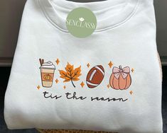 a white t - shirt with the words tis the season on it and an image of a cup of coffee