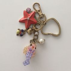 a starfish keychain with charms attached to it's sides on a white surface