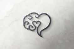 a metal heart with two hearts on it and the word love spelled in cursive writing