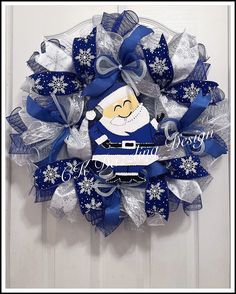 a blue and white christmas wreath hanging on the front door