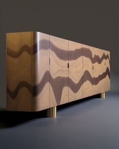 a cabinet that is made out of wood and has wavy designs on the doors, along with brass legs