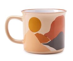 a coffee mug with mountains and sun in the middle on a white background, it has a gold rim