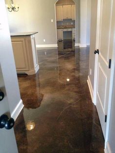 an open door leading to a kitchen and living room in a house with marble floors