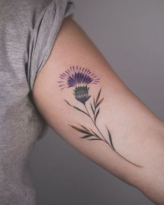 a woman's arm with a flower tattoo on the left side of her arm