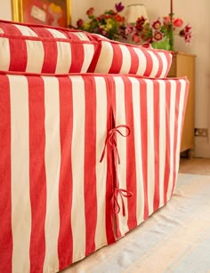 two red and white striped couches sitting on top of a floor next to each other