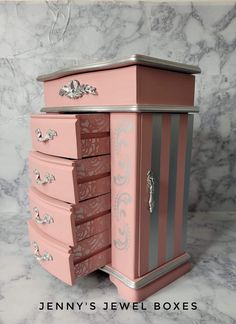 a pink dresser with silver trim and drawers