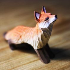 a small toy fox sitting on top of a wooden table