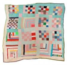 a multicolored patchwork quilt is displayed on a white surface