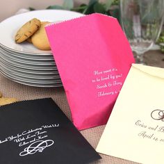 a table topped with lots of plates and paper bags filled with cookies next to each other