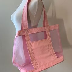 a pink tote bag sitting on top of a white mannequin