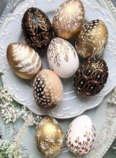 a white plate topped with brown and gold decorated eggs