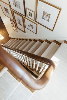 a staircase with pictures on the wall above it