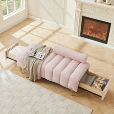 a living room with a pink couch and fireplace