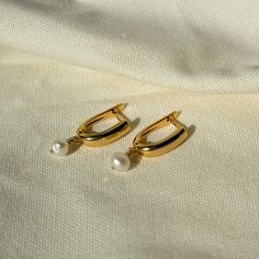 Enhance your elegance with these stunning gold leverback earrings featuring a delicate pearl detail. Perfect for any occasion, these earrings combine classic charm with modern sophistication. Whether you're dressing up for a special event or adding a touch of luxury to your everyday look, these earrings are a must-have addition to your jewelry collection. Features: Material: High-quality gold plating and genuine pearls Design: Leverback style with a timeless pearl accent Length: Approximately 1 inch Closure: Secure and comfortable leverback closure Occasions: Ideal for weddings, parties, and everyday wear Gift: Perfect for birthdays, anniversaries, and special occasions Classic Formal Dangle Huggie Earrings, Formal Huggie Hoop Earrings With Pearl Drop, Elegant Teardrop Huggie Earrings With Lever Back, Everyday Gold Huggie Pearl Earrings, Everyday Gold Earrings With Pearl Pendant, Classic Gold Earrings With Pearl Charm, Classic Gold Plated Earrings With Pearl Pendant, Gold Minimalist Pearl Earrings Tarnish Resistant, Elegant Formal Huggie Earrings With Pearl Drop