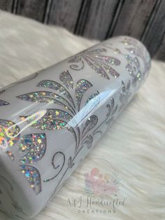 a close up of a silver case on a white furnishing with colorful glitters