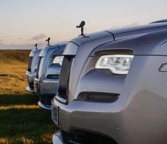 several cars parked in a row on the grass with their lights turned on and there is no image here to provide a caption for