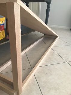 a wooden shelf sitting on top of a tiled floor