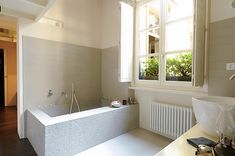 a bathroom with a bathtub, sink and window