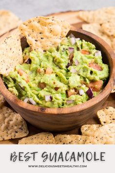 a wooden bowl filled with guacamole surrounded by tortilla chips and salsa