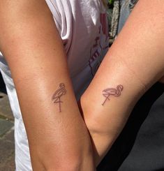 two people with matching tattoos on their arms, one holding the other's arm