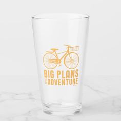 a glass with the words, big plans and adventure written on it in orange ink