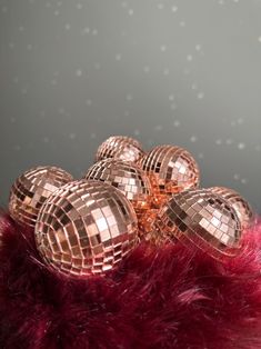 several shiny disco balls sitting on top of a red fur