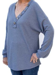 Take a look at our fun Indigo Blue Waffle Knit V Neck Top Made out of soft waffle knit fabric Fabric content: 96% Polyester, 4% Spandex Color: Indigo blue Banded V neck with button detail Long semi full sleeves with a cuff Raw edge design detail on some seams Back length from top to bottom 25" Blue Buttoned Tops For Loungewear, Blue Waffle Knit Top For Fall, Fall Waffle Knit Henley For Loungewear, Blue Knit Tops With Button Closure, Casual Blue Long Sleeve Henley, Waffle Knit V-neck Sweater In Loose Fit, Soft-washed Cotton V-neck Tops, Waffle Knit V-neck Tops For Layering, Fall Waffle Knit V-neck Top