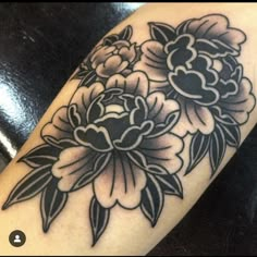 a black and white flower tattoo on the arm