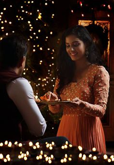 a woman in an orange dress is serving food