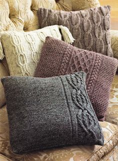 four knitted pillows sitting on top of a couch