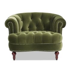 a green velvet chair with studded trimmings on the arms and back, sitting in front of a white background